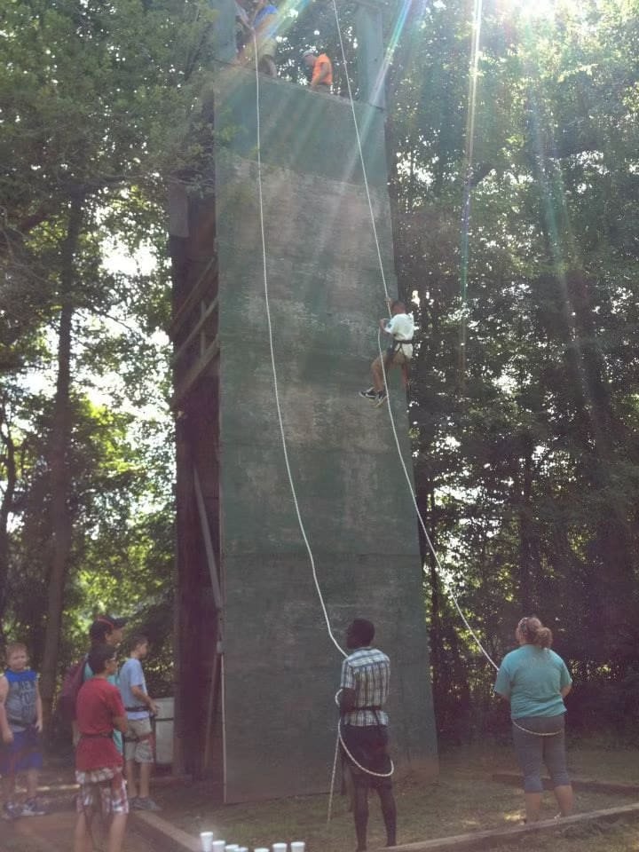 Kid rappelling down tower.